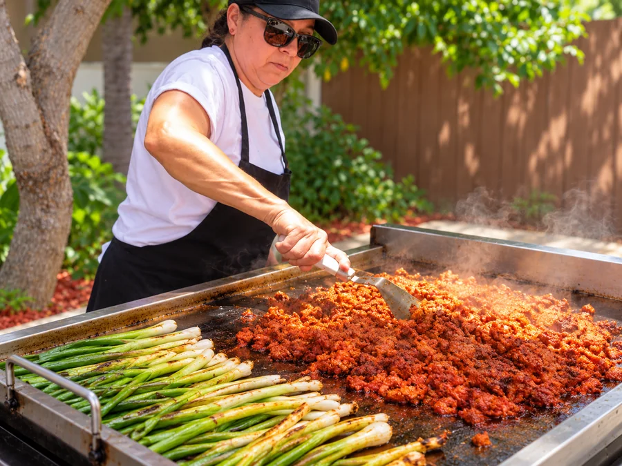 Gloria grilling al pastor and green onions