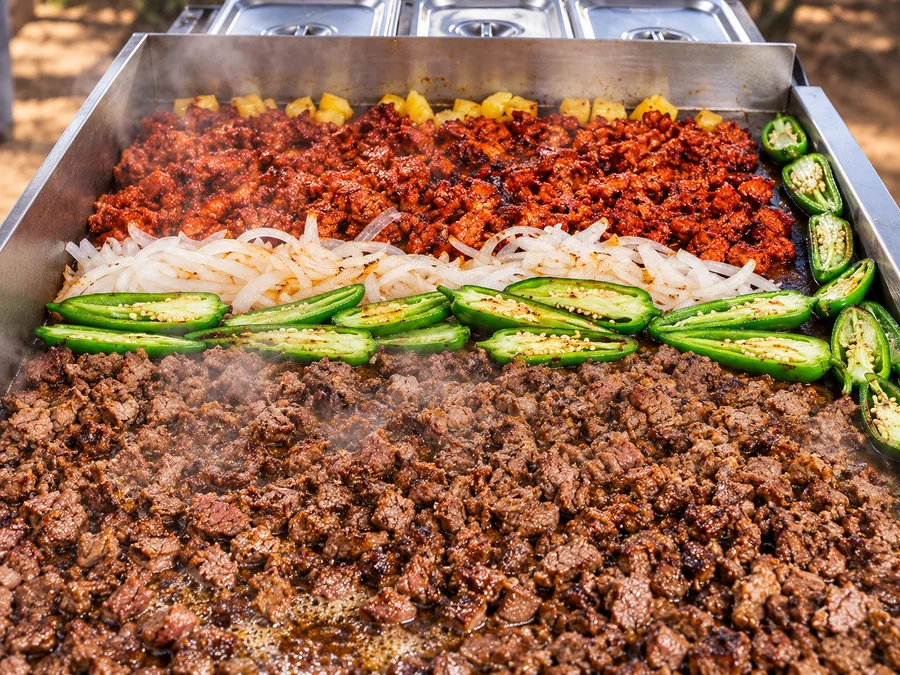 Al pastor, carne asada and grilled jalapeños on the plancha